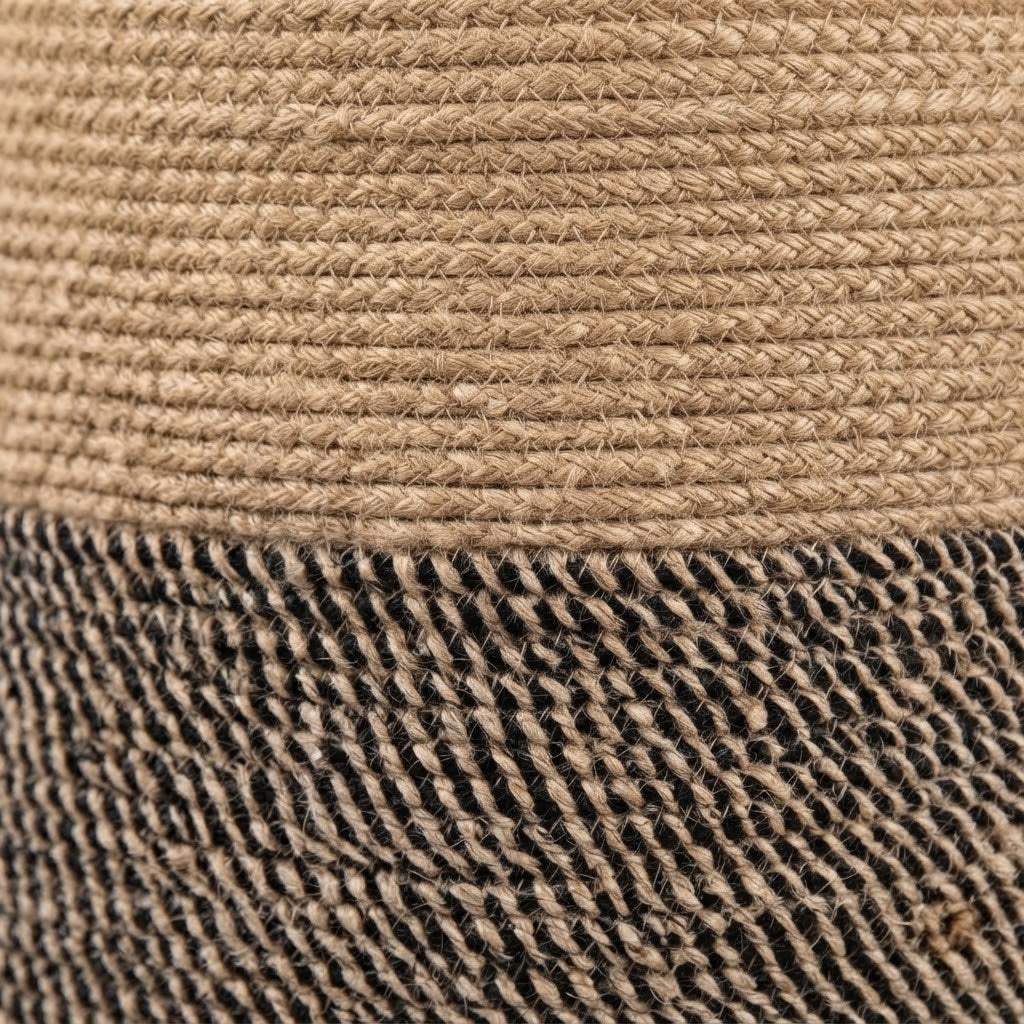 Close-up texture of woven rope basket fabric: tan top layer and black-and-brown bottom.