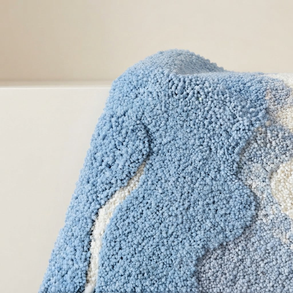 Bath mat pile texture detail in light blue with off-white wave line