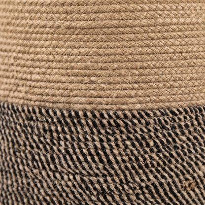 Close-up texture of woven rope basket fabric: tan top layer and black-and-brown bottom.