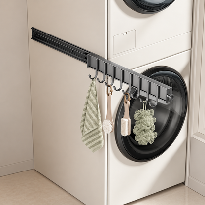 Dark sliding hook rail with curved hooks holding towel and bath puffs by washer