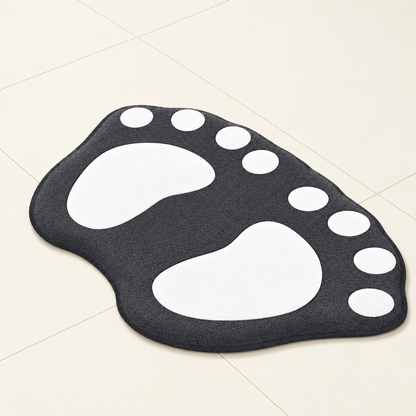 Paw-shaped bath mat in dark charcoal with white paw prints and white dot accents