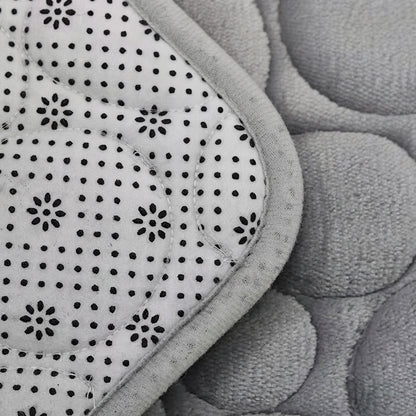 Grey microfibre bath mat texture with non-slip dot pattern, close-up view.