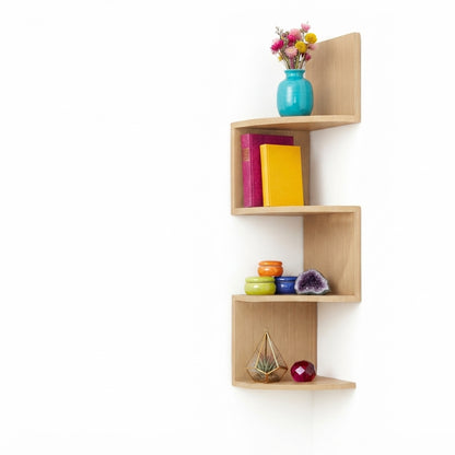 Light wood corner floating 3-tier shelf with vase and colorful books on open cubbies