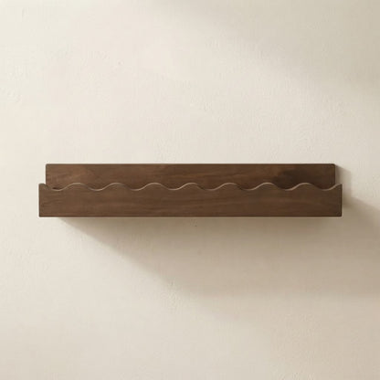 Walnut wooden floating wall shelf with scalloped front edge and clean flat surface