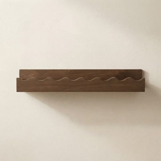Walnut wooden floating wall shelf with scalloped front edge and clean flat surface