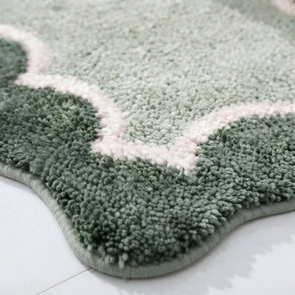 Scalloped microfibre non-slip bath mat in dark green with pale pink border pattern