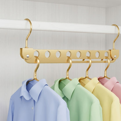 Gold 8-slot foldable clothes hanger with several shirts hanging from the hooks.