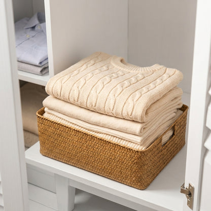 Woven seagrass storage basket holding folded cream towels