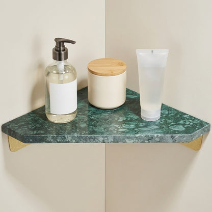 Green marble corner floating shelf with gold supports and bathroom toiletries on top