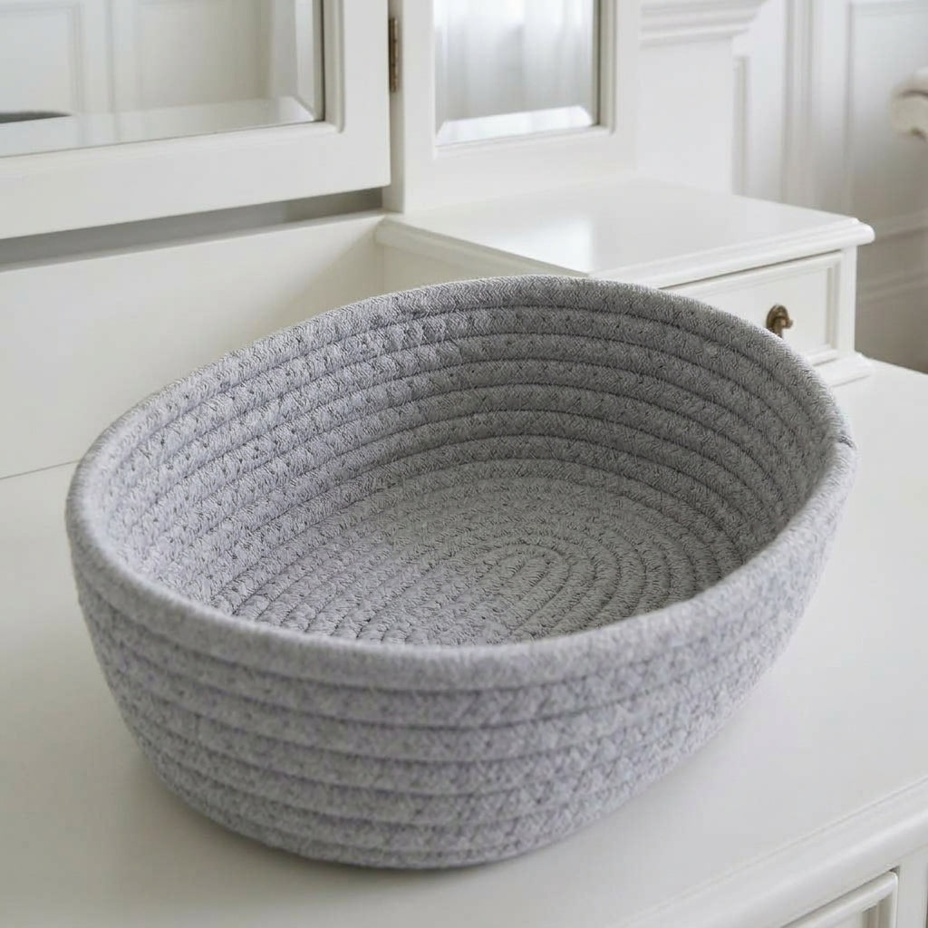 Grey woven cotton rope oval storage basket with ribbed sides and open top