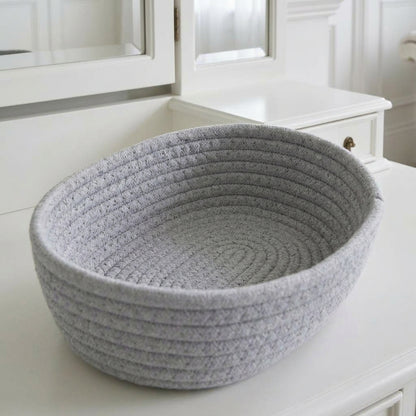 Grey woven cotton rope oval storage basket with ribbed sides and open top