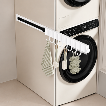 White pull-out sliding hook rail with curved hooks holding kitchen cloths on appliance