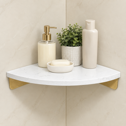 White marble corner floating shelf with gold supports, bottles and plant decor on top