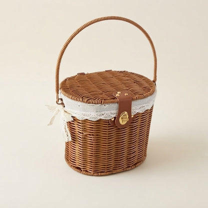 Faux rattan picnic basket with arched handle, round lid, and white lace-lined cover