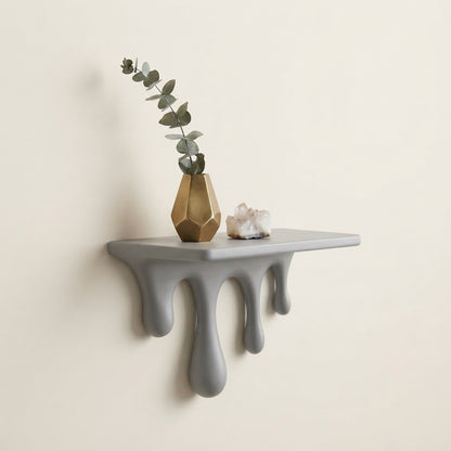 Grey floating wall shelf with sculpted dripping legs and three rounded drips