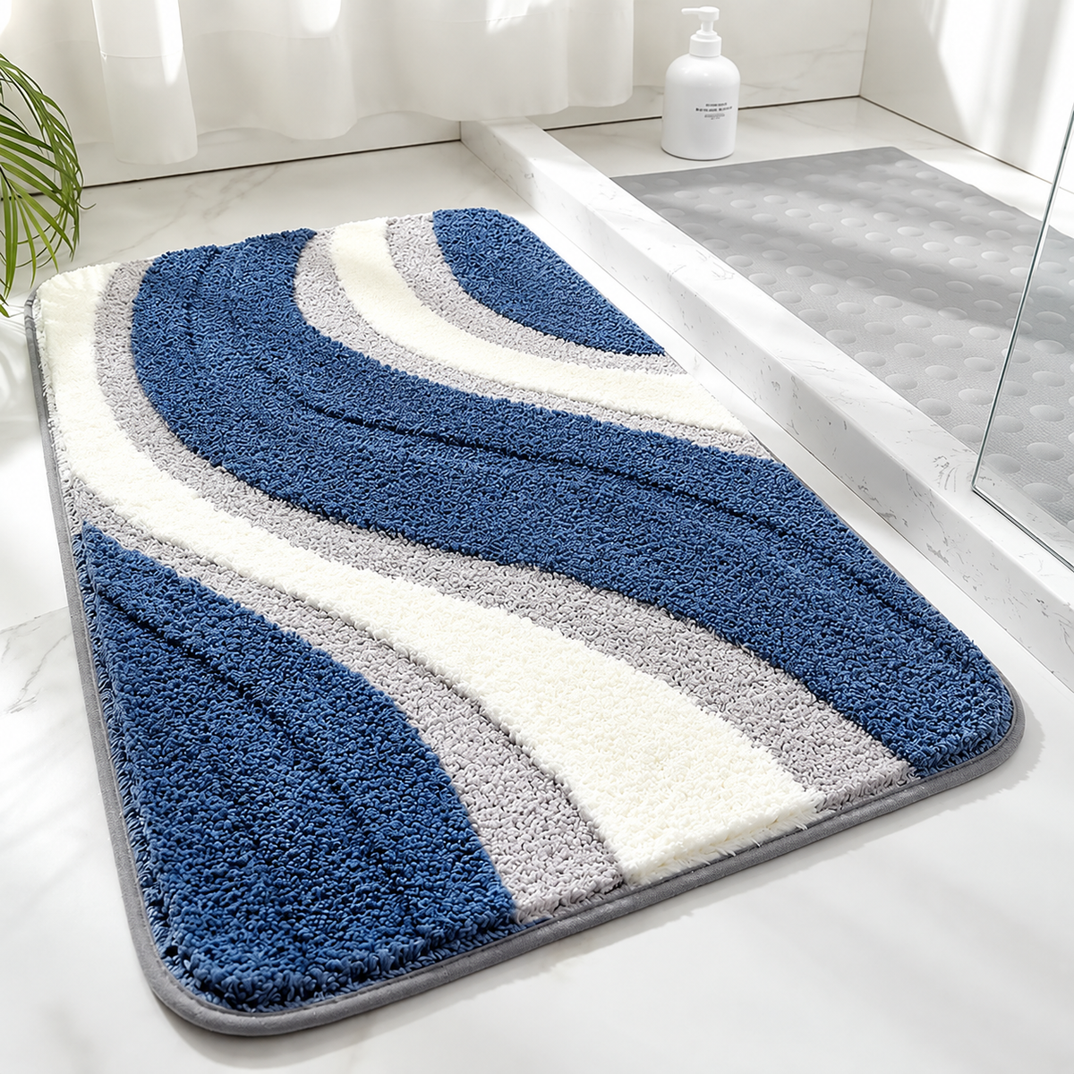 Tufted wave stripe bath mat with blue and white bands, gray accents, non-slip backing.