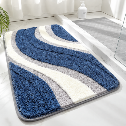 Tufted wave stripe bath mat with blue and white bands, gray accents, non-slip backing.