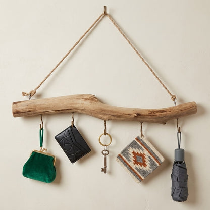 Driftwood hook rail with rope hanger and loop hooks holding small bags, keys, and umbrella