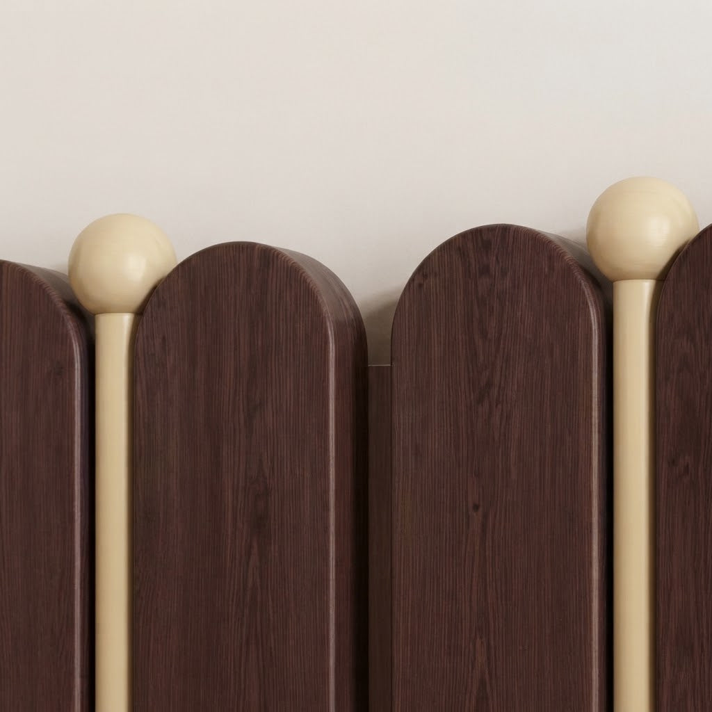 Close-up view of arched wooden hook backboard with light gold ball finials