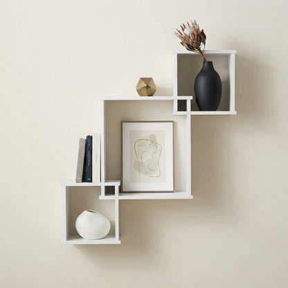 White cube wall shelf with open cubbies, styled with framed art and accessories
