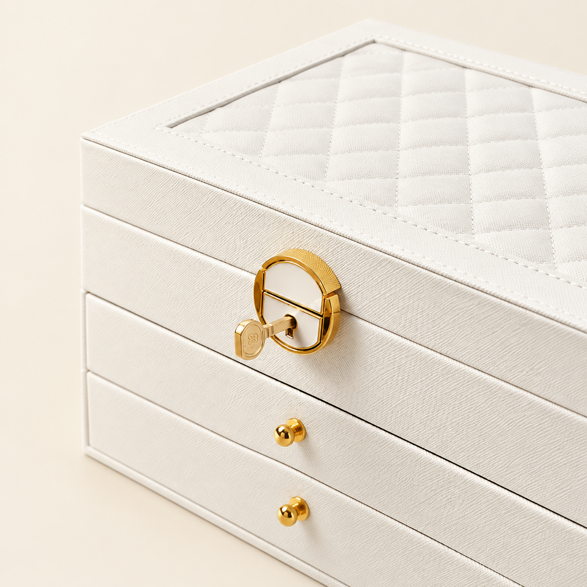 White leather quilted jewelry box with gold-tone loop handle and two front drawers