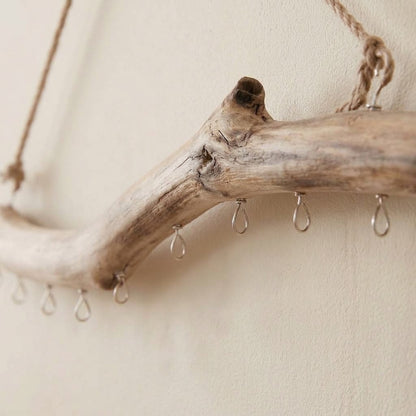 Close-up of driftwood multi-hook rail end with rope loop and hanging metal hooks