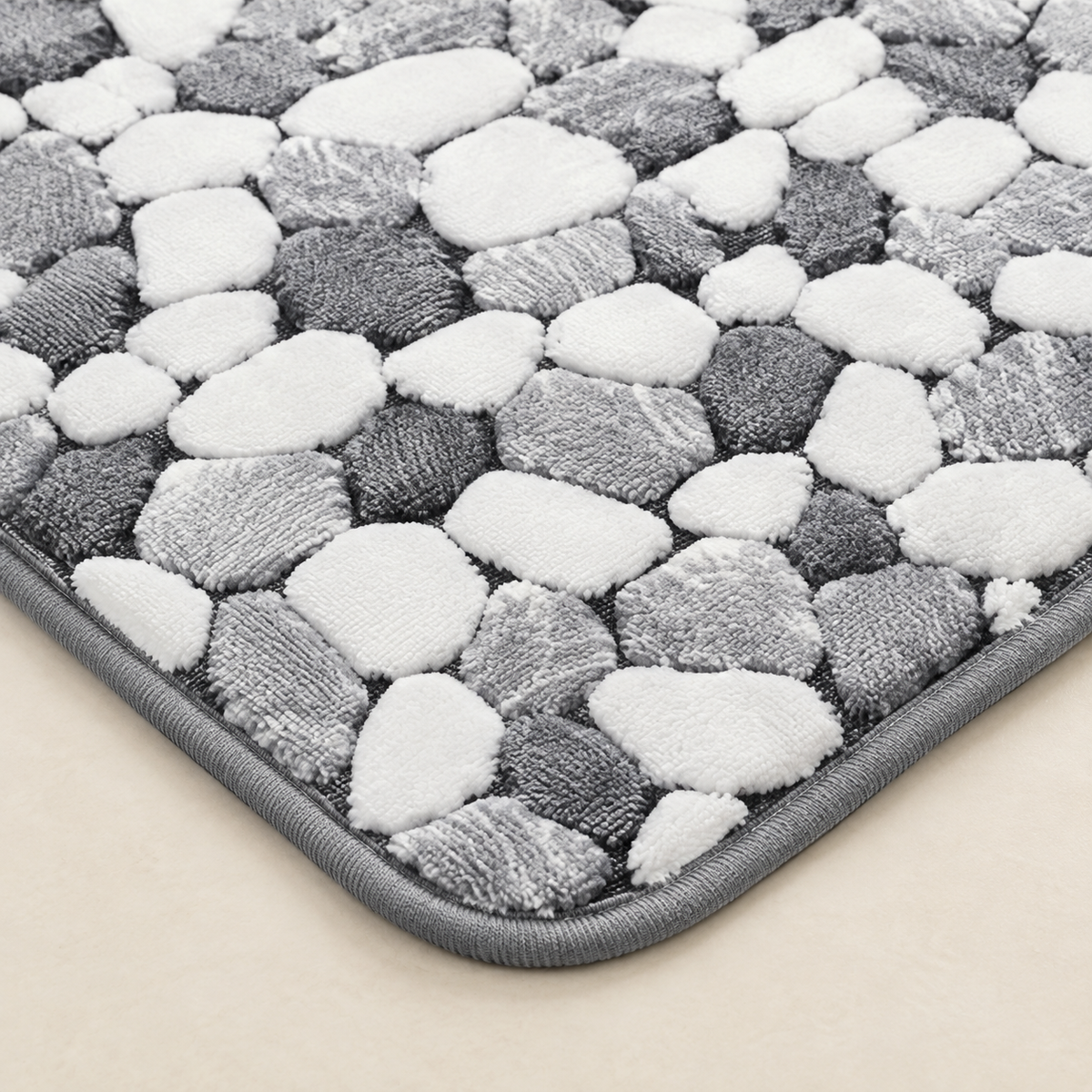 Pebble-pattern non-slip bath mat with gray and white textured surface close-up