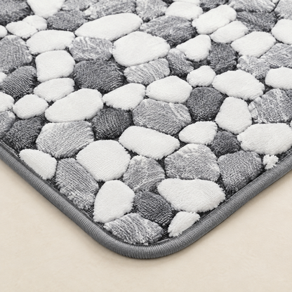 Pebble-pattern non-slip bath mat with gray and white textured surface close-up