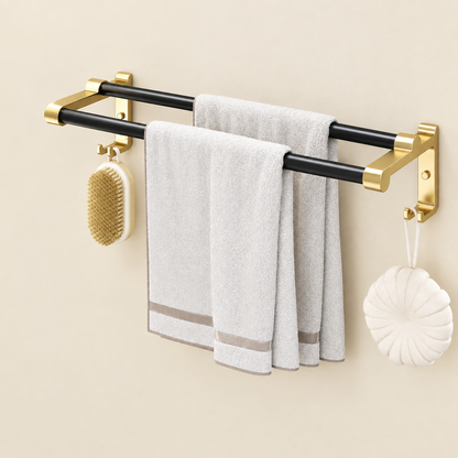 Wall-mounted towel rack with black rails, gold wall mounts, hanging brush and towels