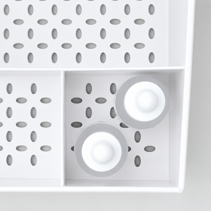 White makeup organizer grid with circular compartments and round accessory holders
