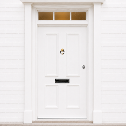 Brass and dark ring door knocker centered on a white front door