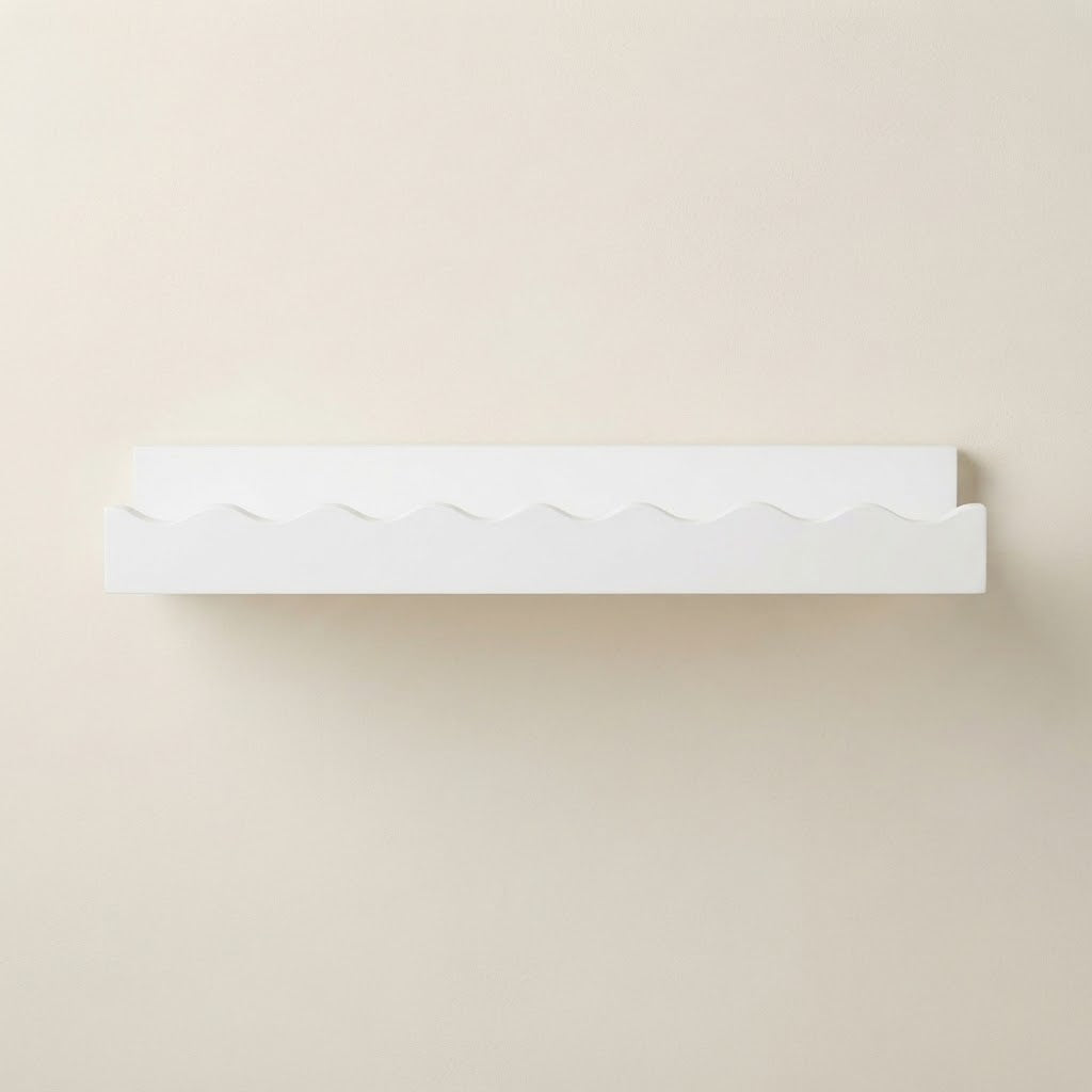White wooden floating wall shelf with scalloped front edge and smooth underside