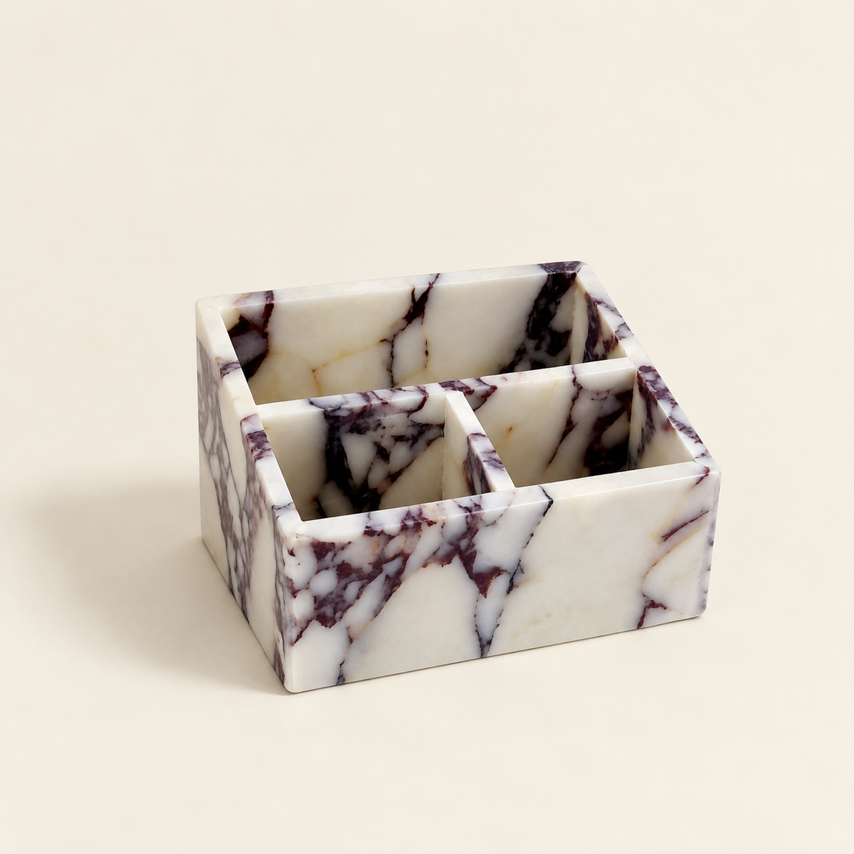 Calacatta marble makeup organiser with six compartments and purple veining pattern.