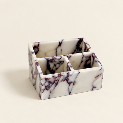 Calacatta marble makeup organiser with six compartments and purple veining pattern.