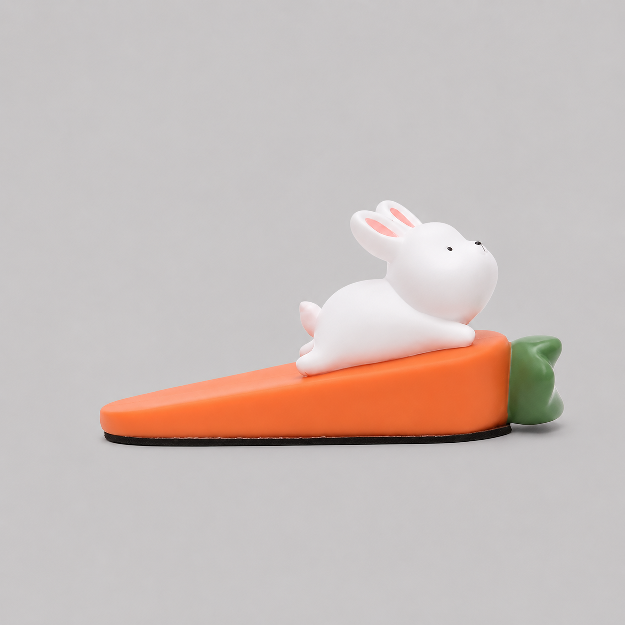 Rabbit-shaped door stop, white rabbit on orange base with green tail detail.