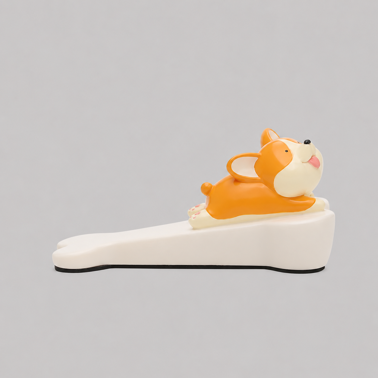 Cat-shaped door stop, orange with white face on white base and black edge.