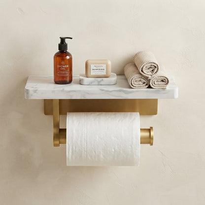 Marble-look toilet roll holder with cylindrical brushed gold arms and toilet paper