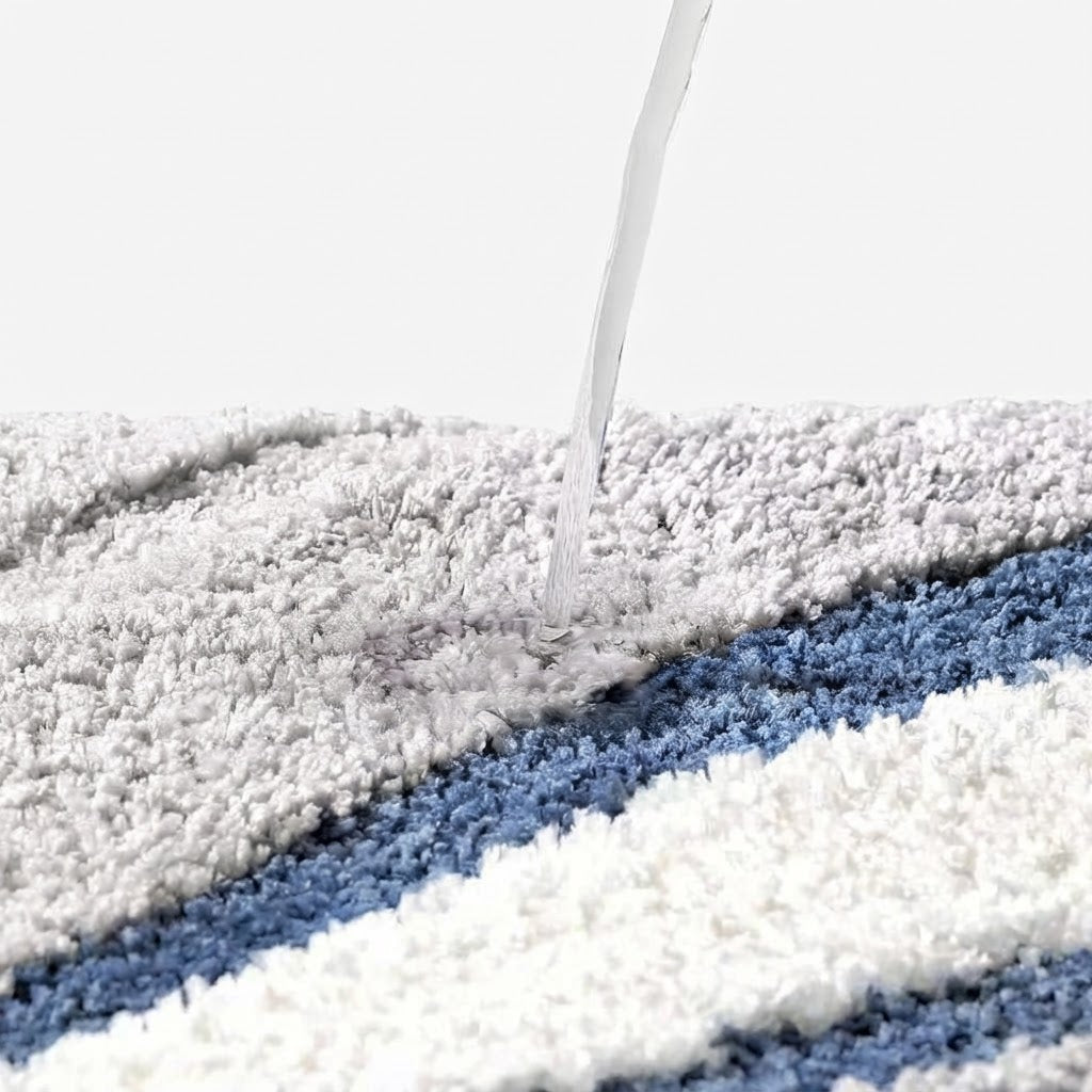 Tufted wave stripe bath mat with water poured onto gray and blue striped pile.