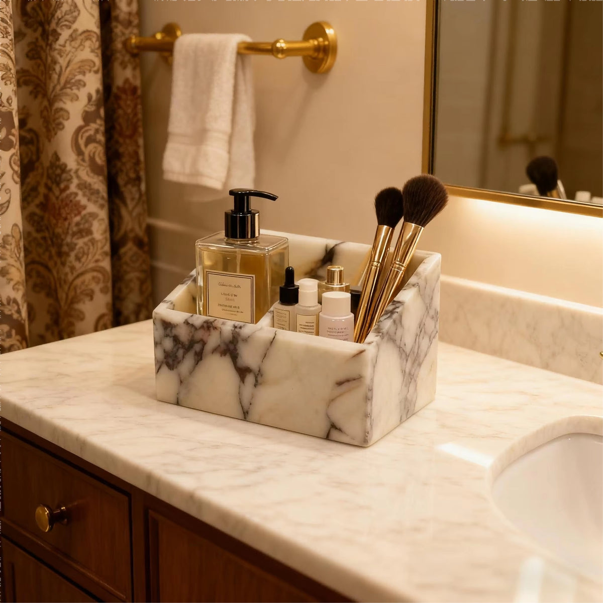 Marble makeup organiser with front dividers holding makeup brushes and bottles on vanity.