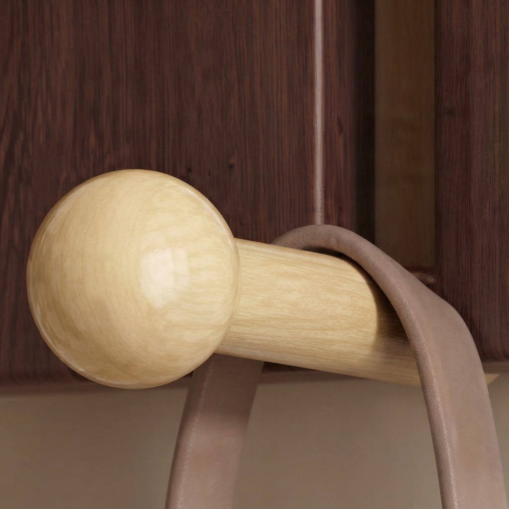 Close-up of a light gold hook with round knob on dark walnut arched wood panel