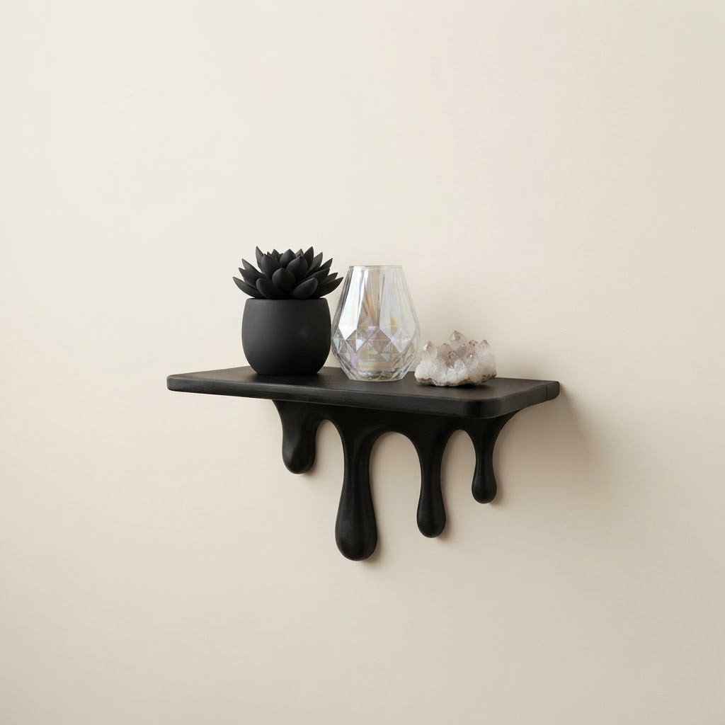 Black floating wall shelf with sculpted dripping legs and three rounded drips