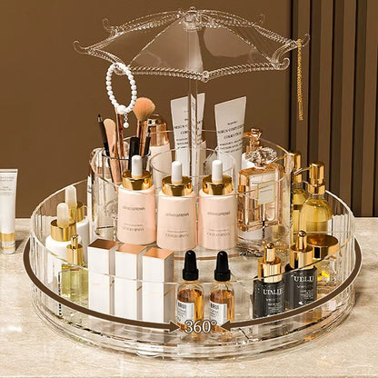 Rotating multi-tier makeup organizer display with clear acrylic base and gold perfume bottles