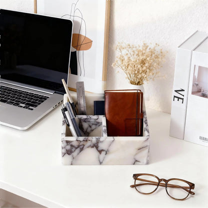 White marble organiser box with compartments holding stationery and small personal items.