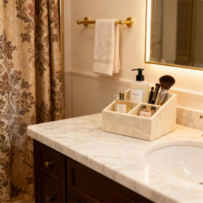 Travertine-style makeup organizer with four compartments holding bottles and makeup tools.
