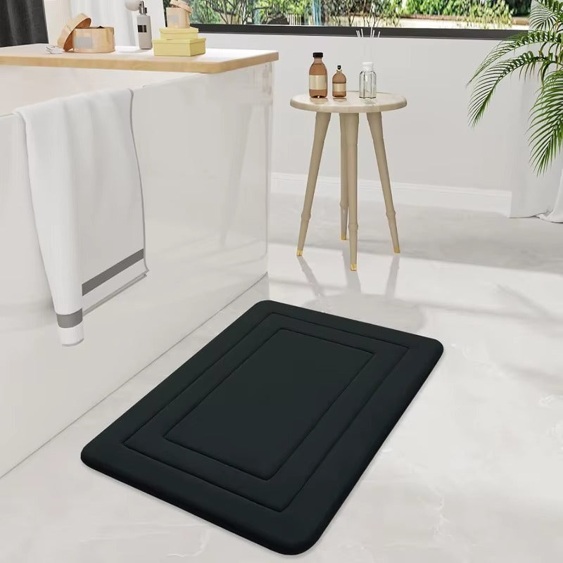Black cushioned non-slip bath mat with raised border and central recessed square