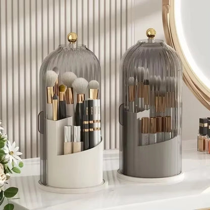 Set of two rotating makeup brush holders with clear domes and gold finials, holding brushes