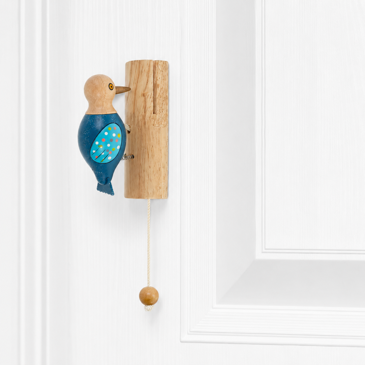 Woodpecker door knocker on wood backplate with blue speckled wings and dangling ball cord