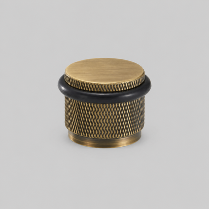 Brass knurled door stop with round wood-tone top cap and black rubber ring
