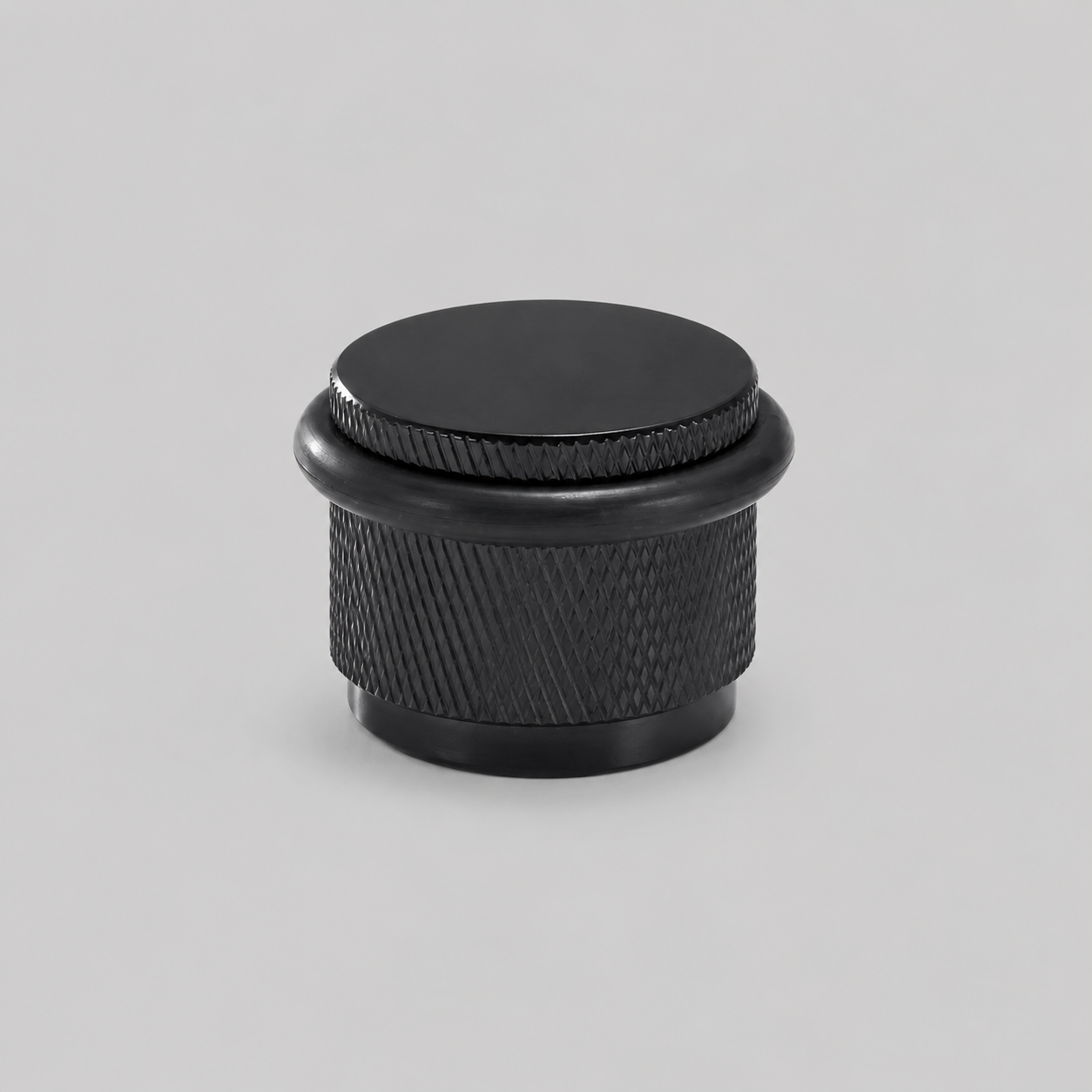 Black knurled door stop with round black top and black rubber base ring