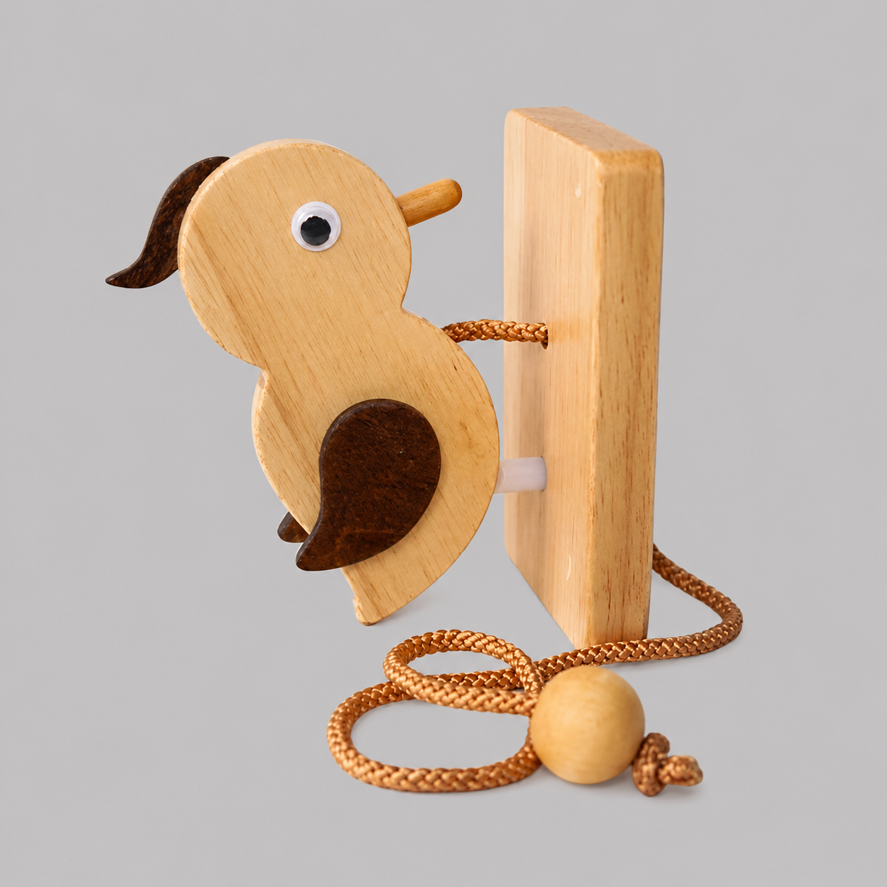 Wooden woodpecker door knocker close-up with metal eye, striker plate, and cord